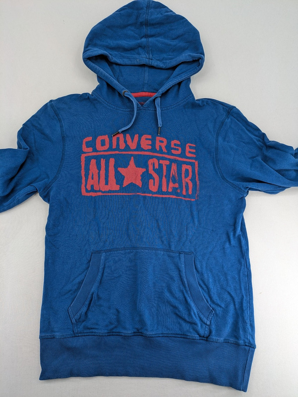 Converse All Star blue zip-through hoodie with red graphic logo and kangaroo pocket.