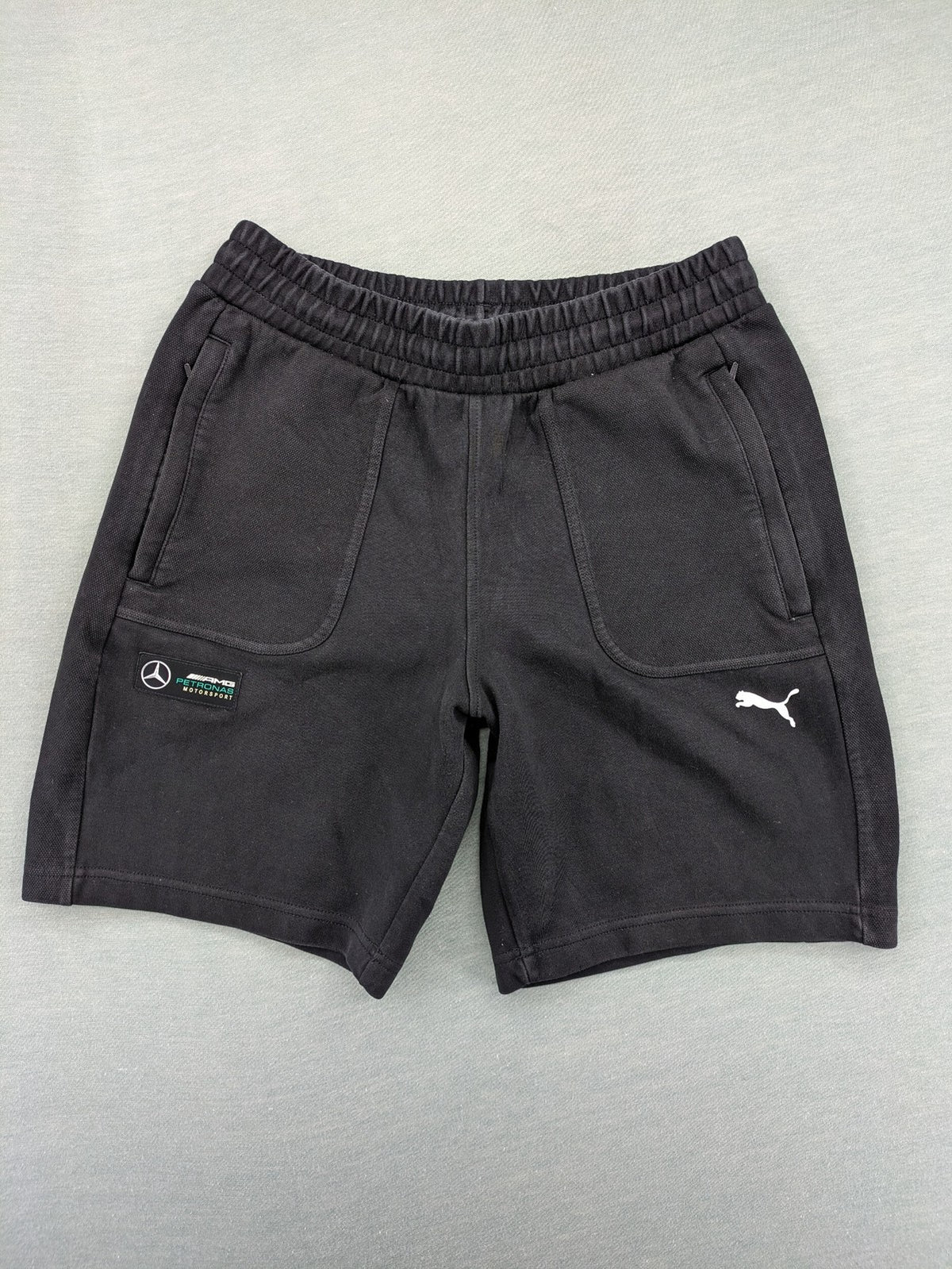 Puma grey sweatshorts featuring Mercedes AMG Petronas logo and elastic waistband.