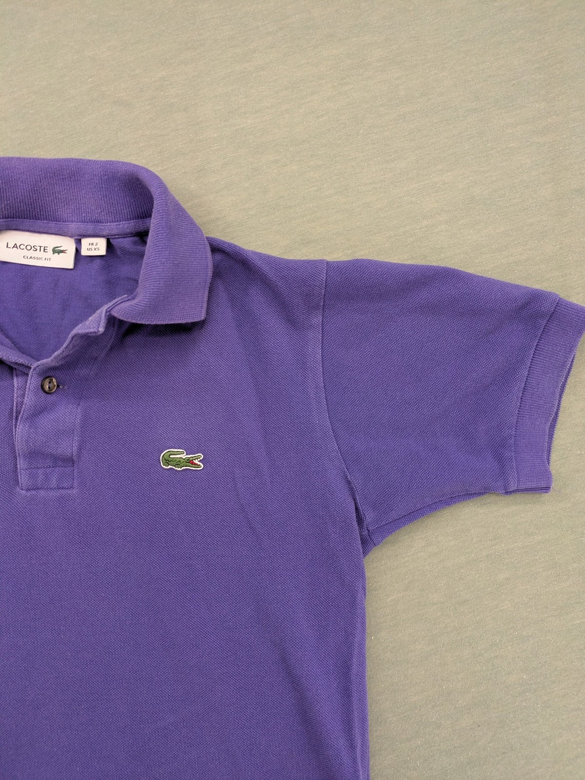 Lacoste purple polo shirt classic fit with embroidered crocodile logo and short sleeves.