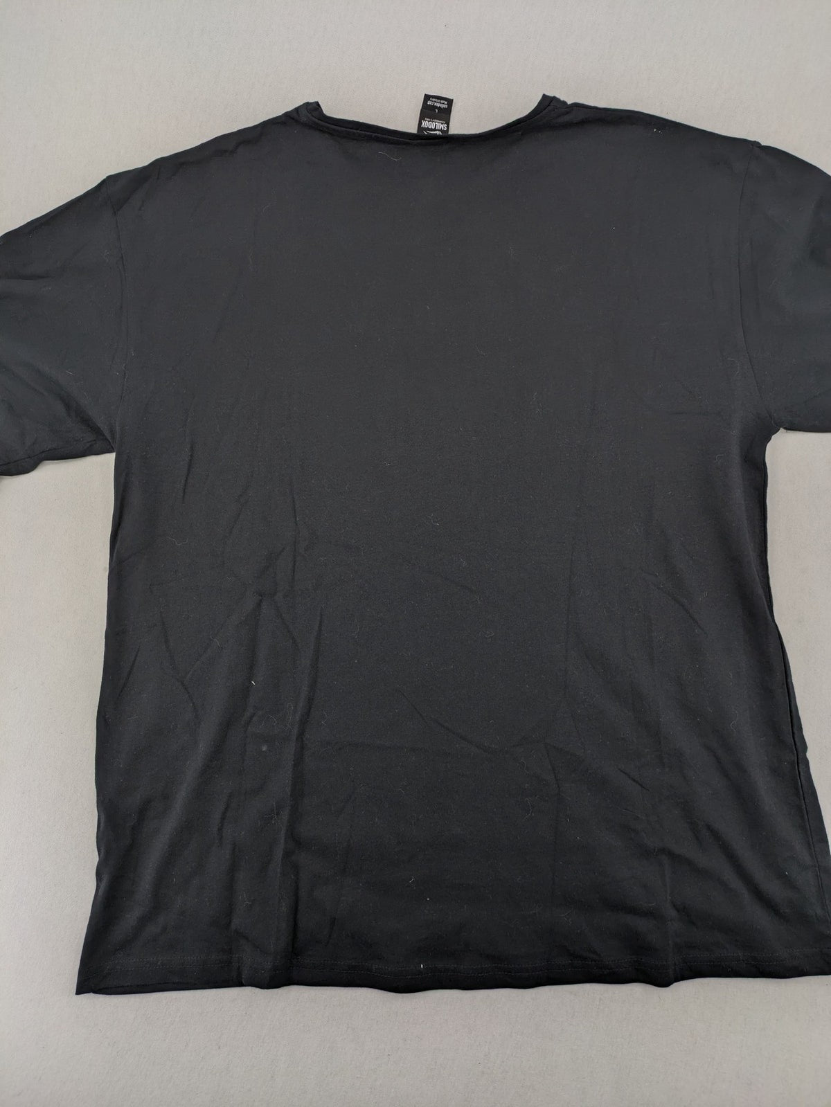 Smilodox black T-shirt minimalist design with subtle brand patch, 100% cotton.