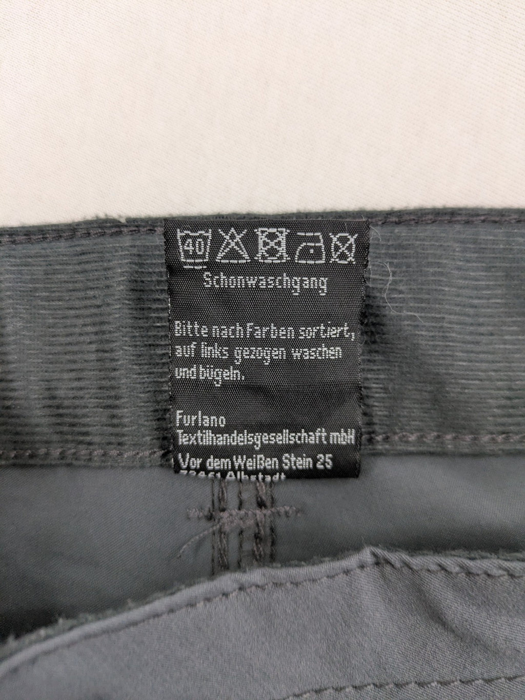 Outdoor grey functional shorts with adjustable velcro waistband and zippered leg pocket.