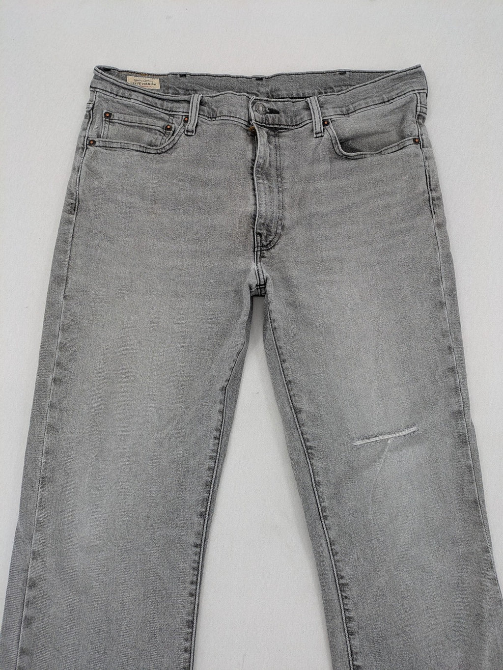 Levi's grey slim fit jeans with distressed knee details and classic logo patch.