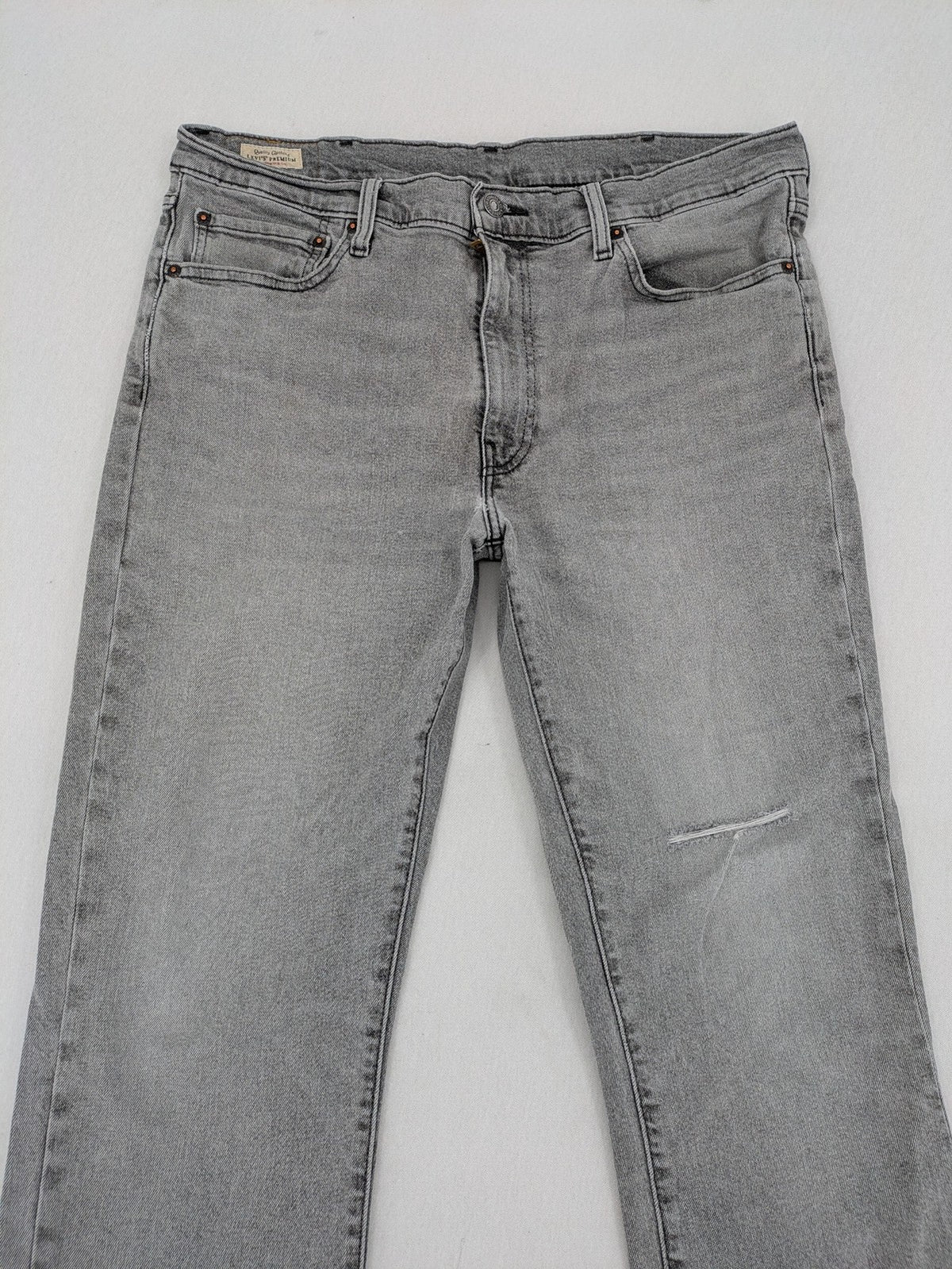 Levi's grey slim fit jeans with distressed knee details and classic logo patch.