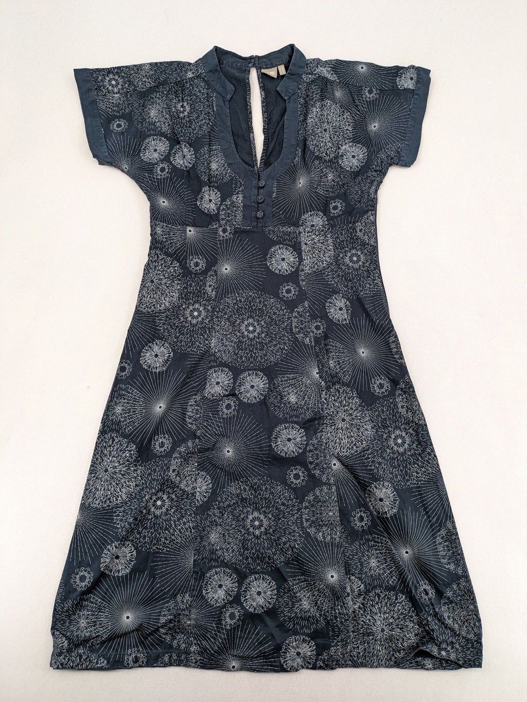 Muster navy dress with white abstract dandelion print, V-neck and collar details.