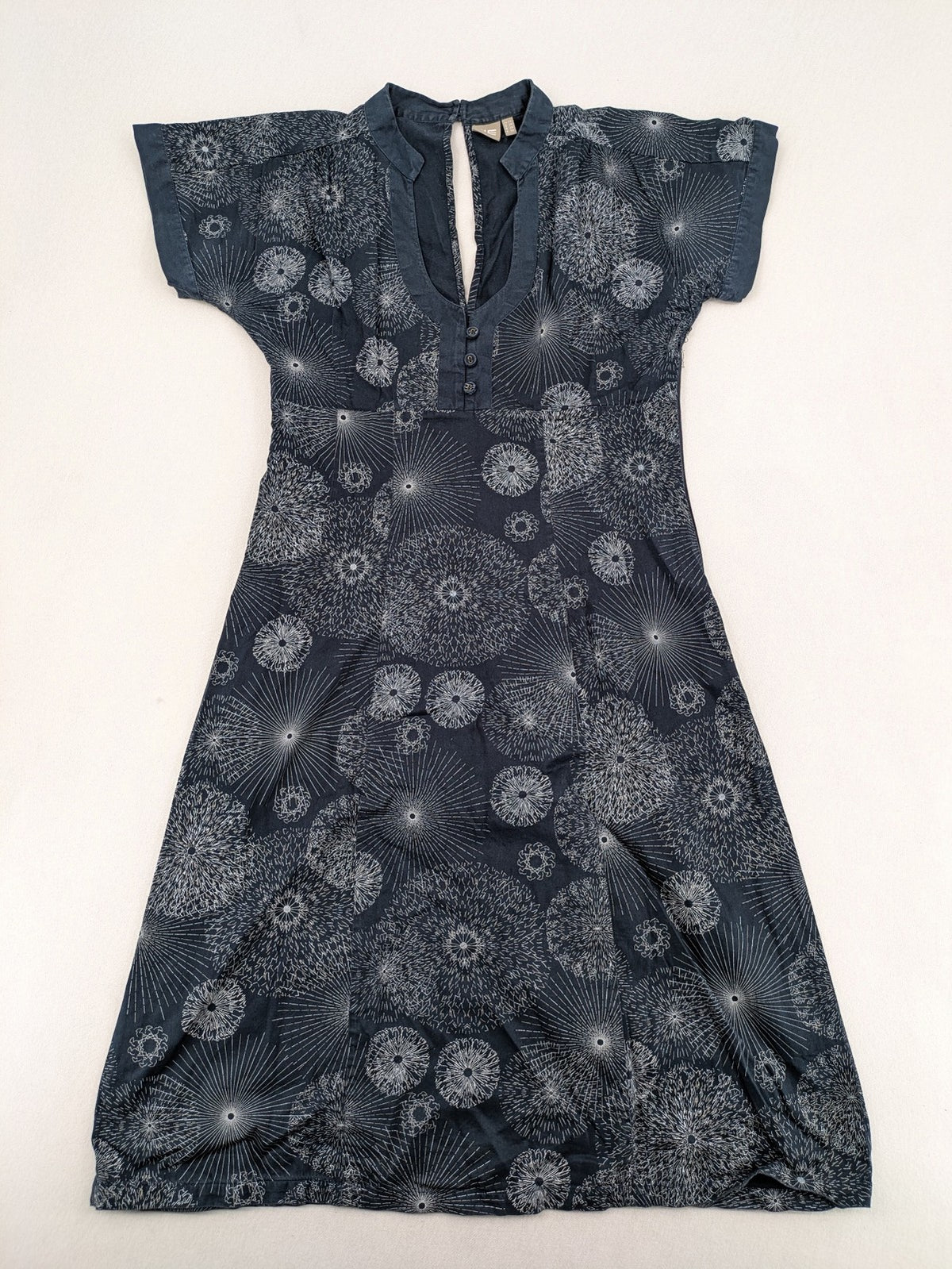 Muster navy dress with white abstract dandelion print, V-neck and collar details.