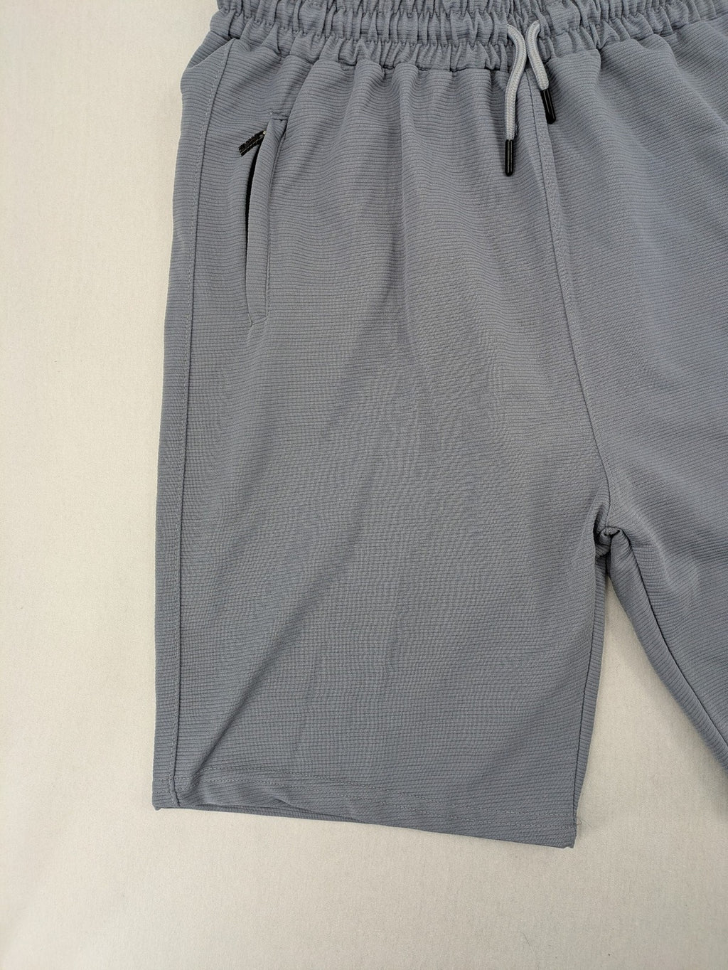 Nike grey shorts with Dri-FIT technology, elastic waistband, and zippered pockets.