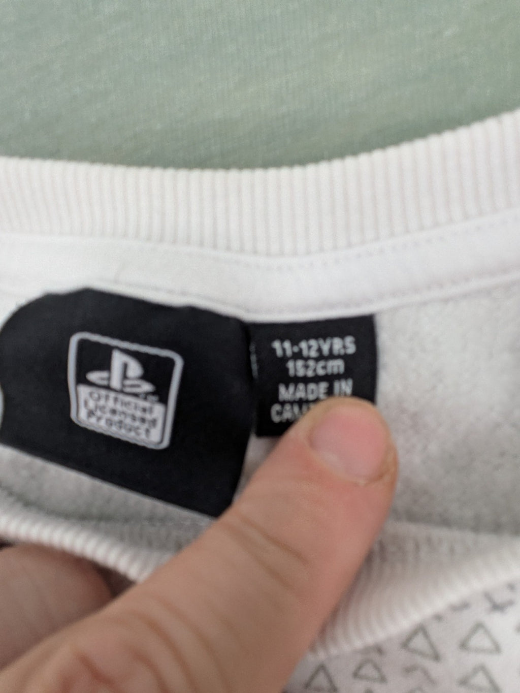 PlayStation grey sweatshirt with white logo and camo pattern featuring controller symbols.