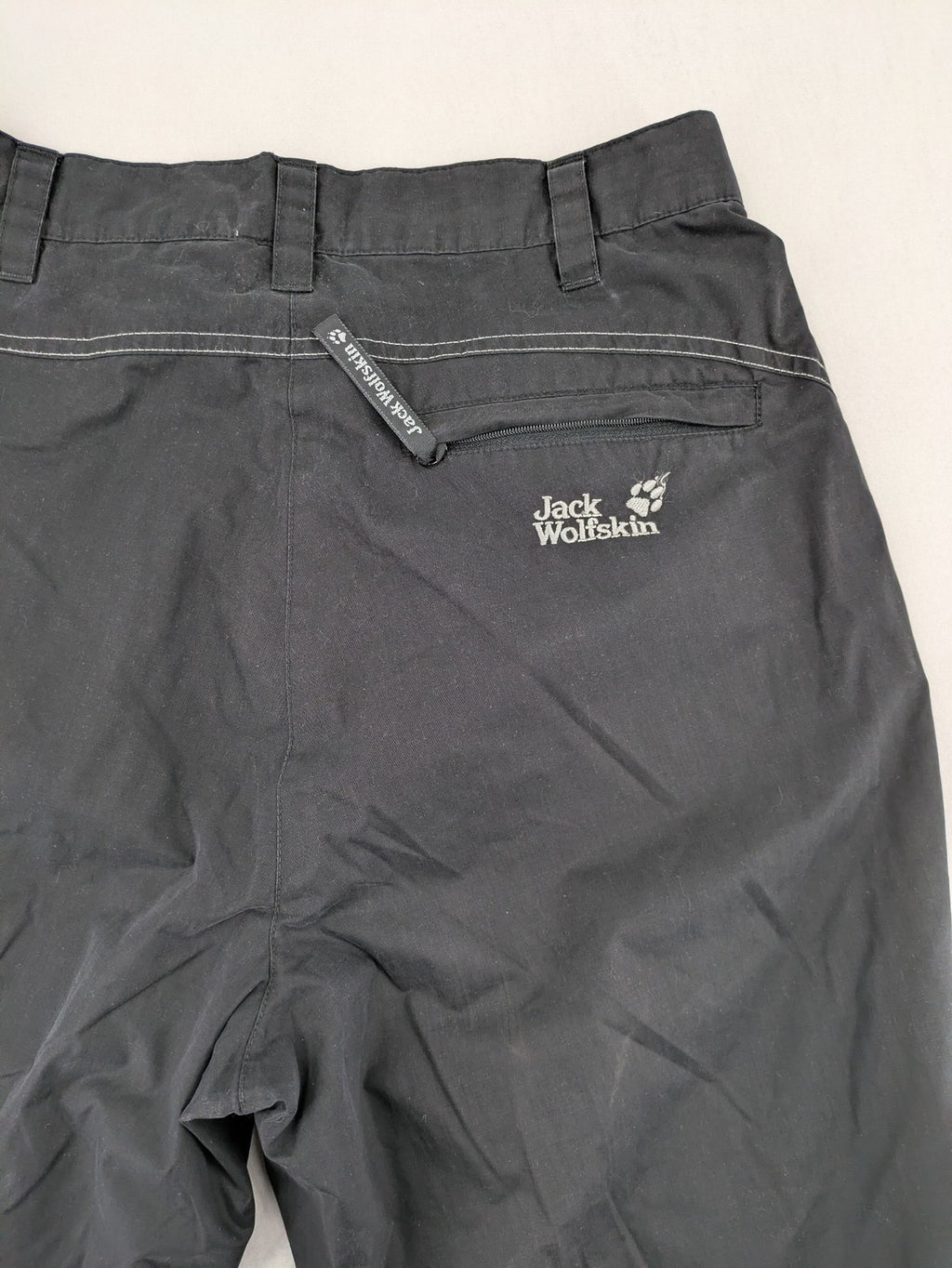 Jack Wolfskin grey outdoor pants with embroidered logo and side zip pocket.