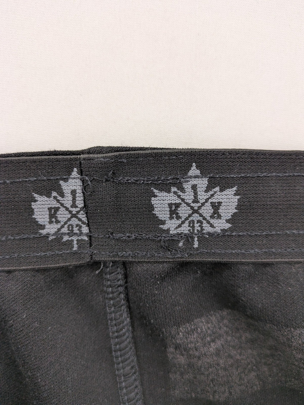 K1X grey joggers with white basketball logo, elastic waistband, and cuffed ankles.