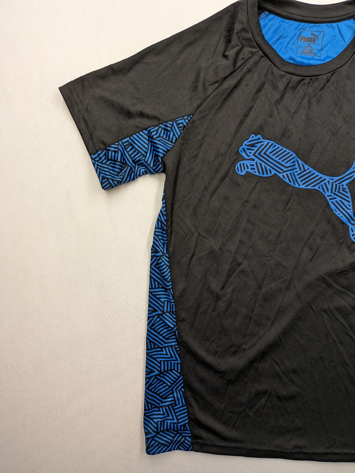 Puma black performance T-shirt with blue geometric side panels and iconic logo.