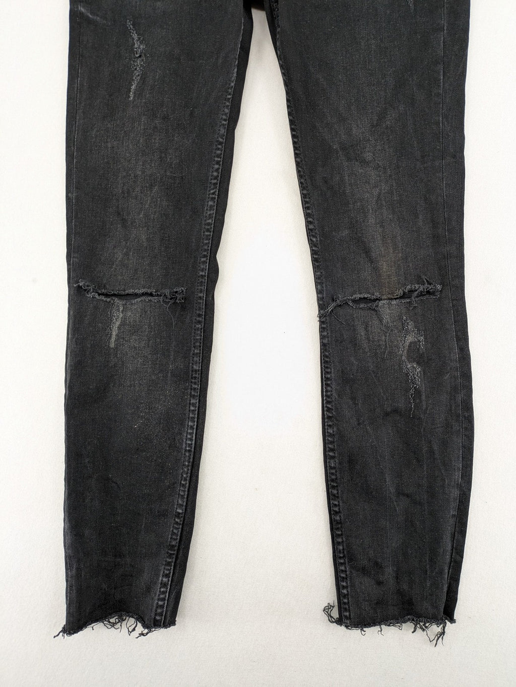 Zara Woman black skinny jeans with distressed details, silver studs, and frayed hem.