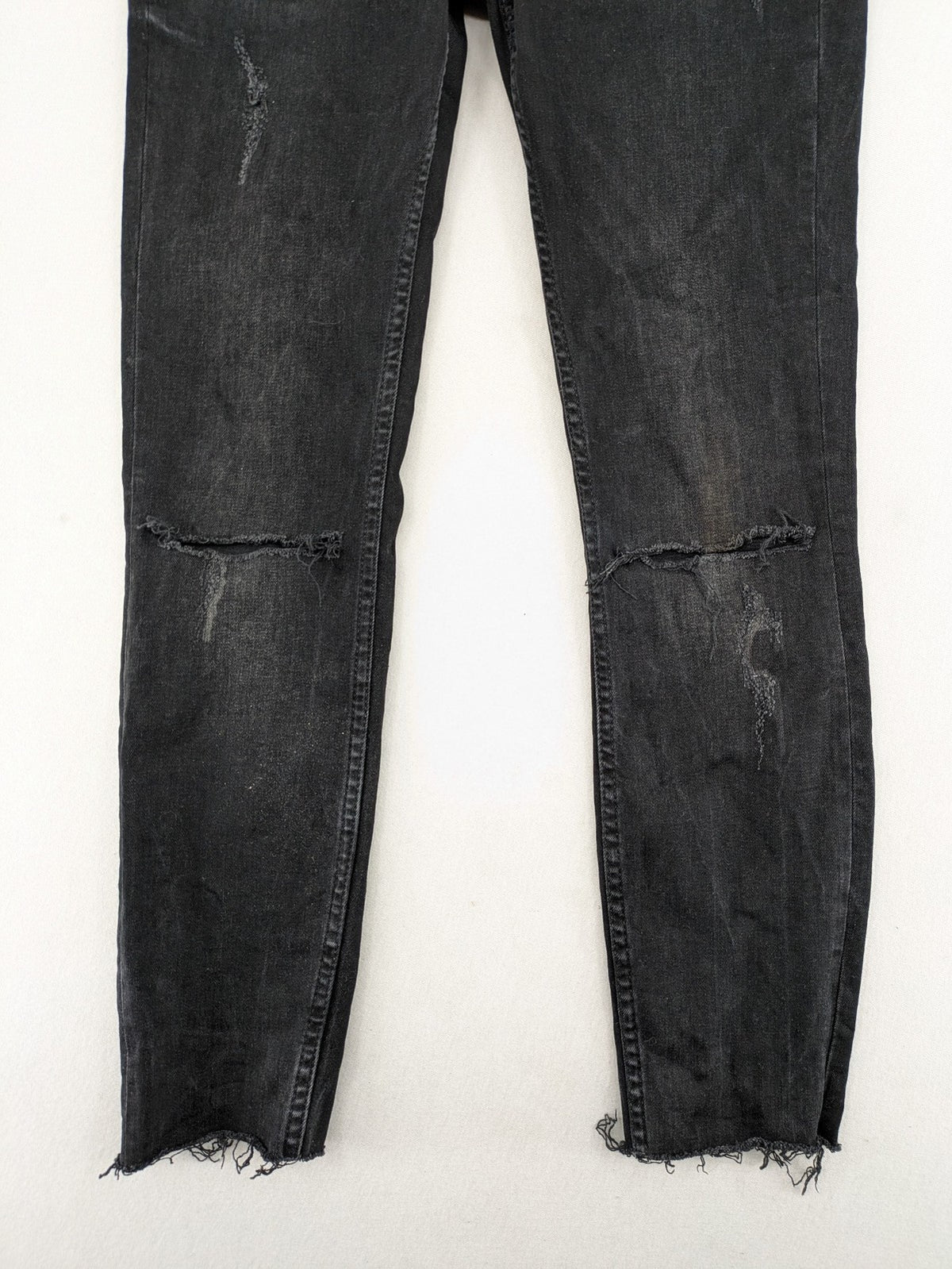 Zara Woman black skinny jeans with distressed details, silver studs, and frayed hem.