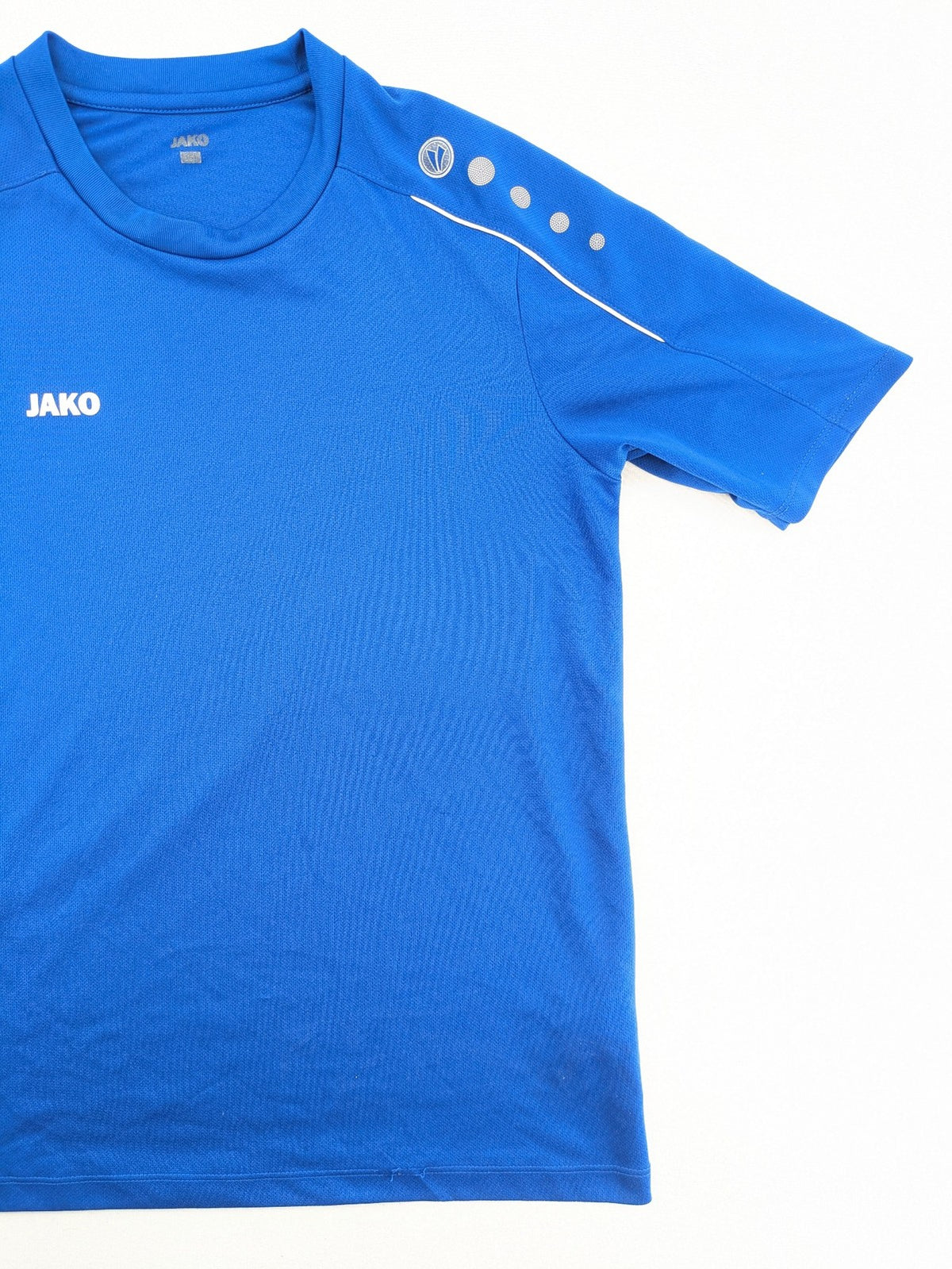 Jako blue short-sleeve training shirt with logo details and breathable polyester material.