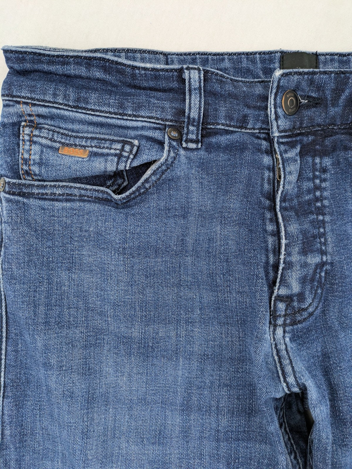 BOSS blue slim fit jeans with logo, five-pocket design, and button fly.