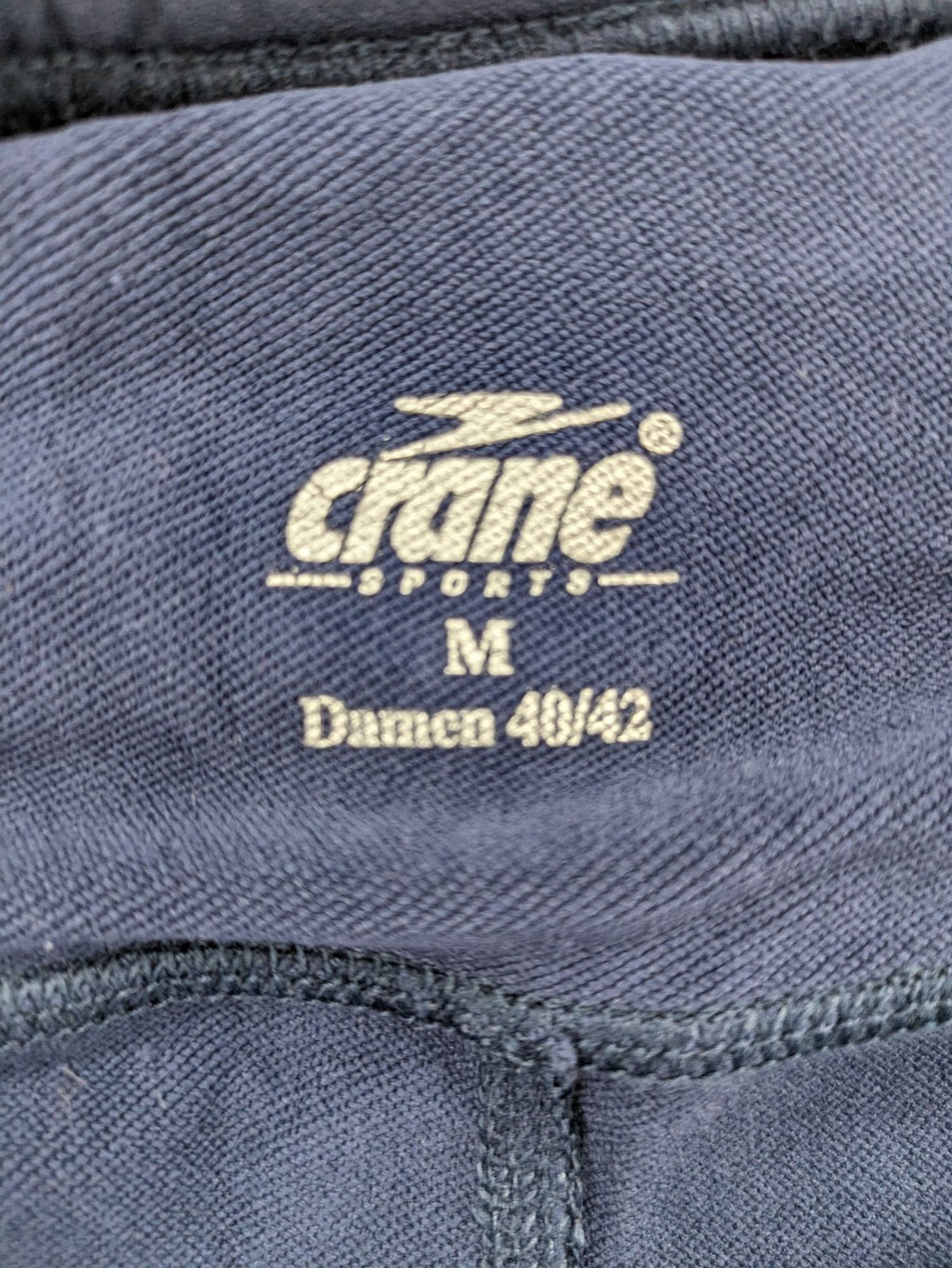 Crane Sports navy running tights with reflective details and zippered ankle openings.