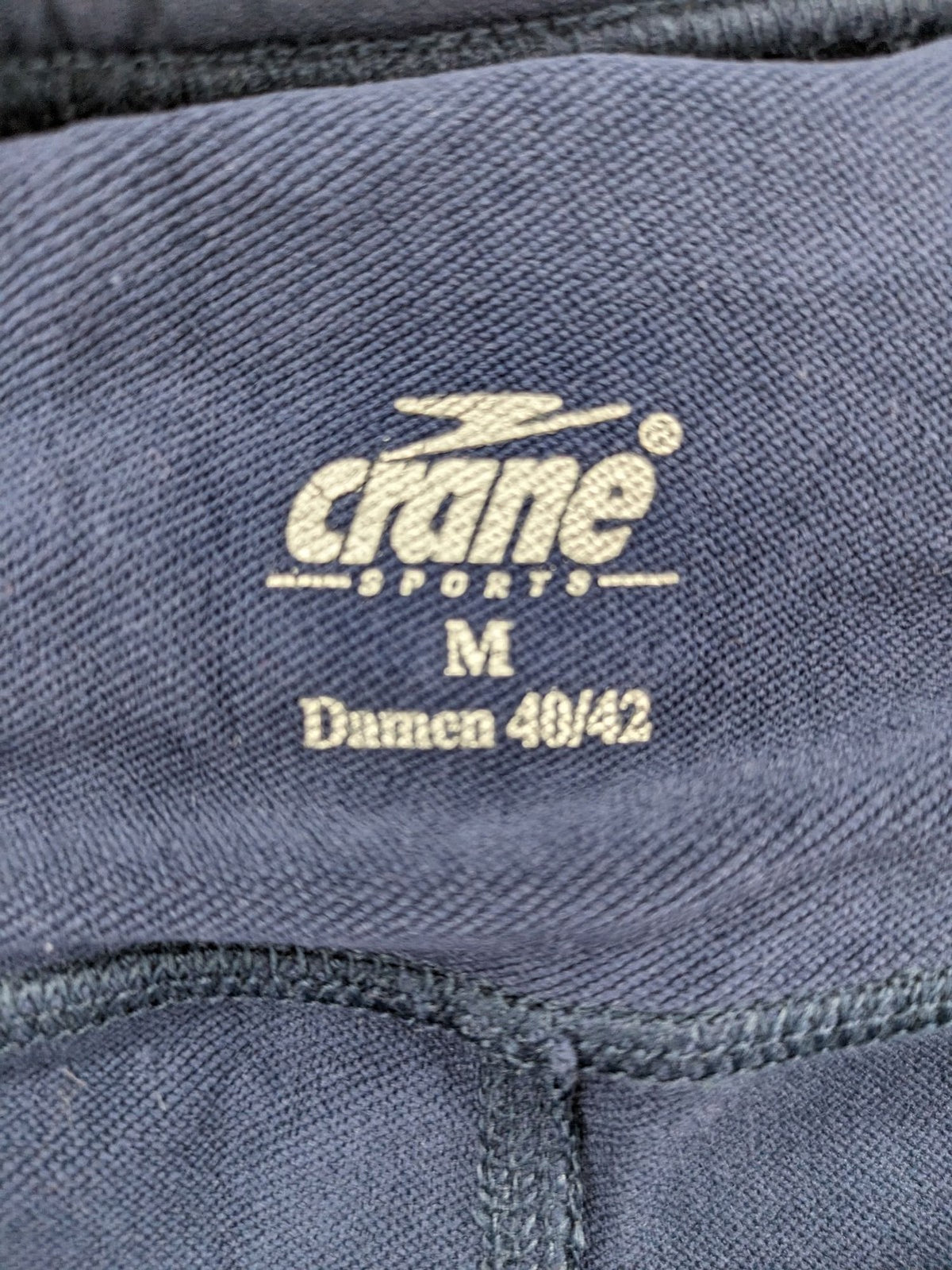 Crane Sports navy running tights with reflective details and zippered ankle openings.