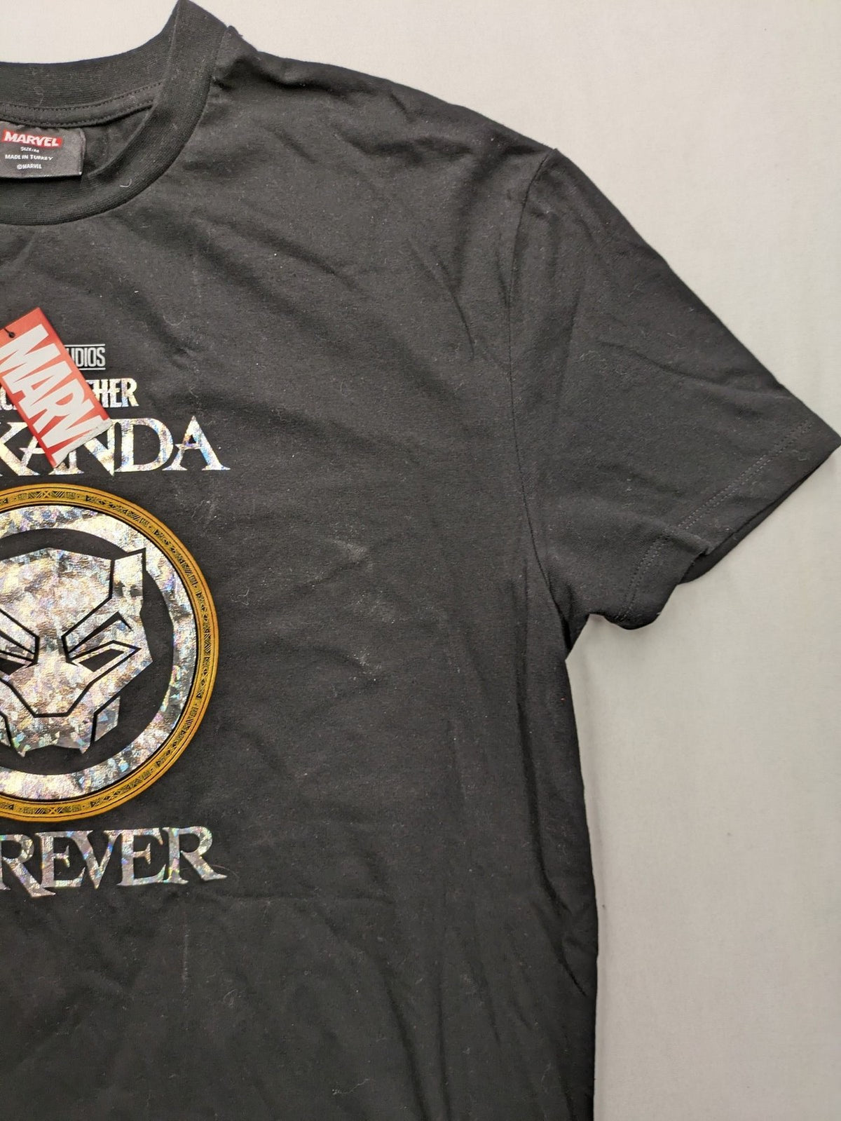 Black Panther black t-shirt foil graphic of Black Panther emblem and text.