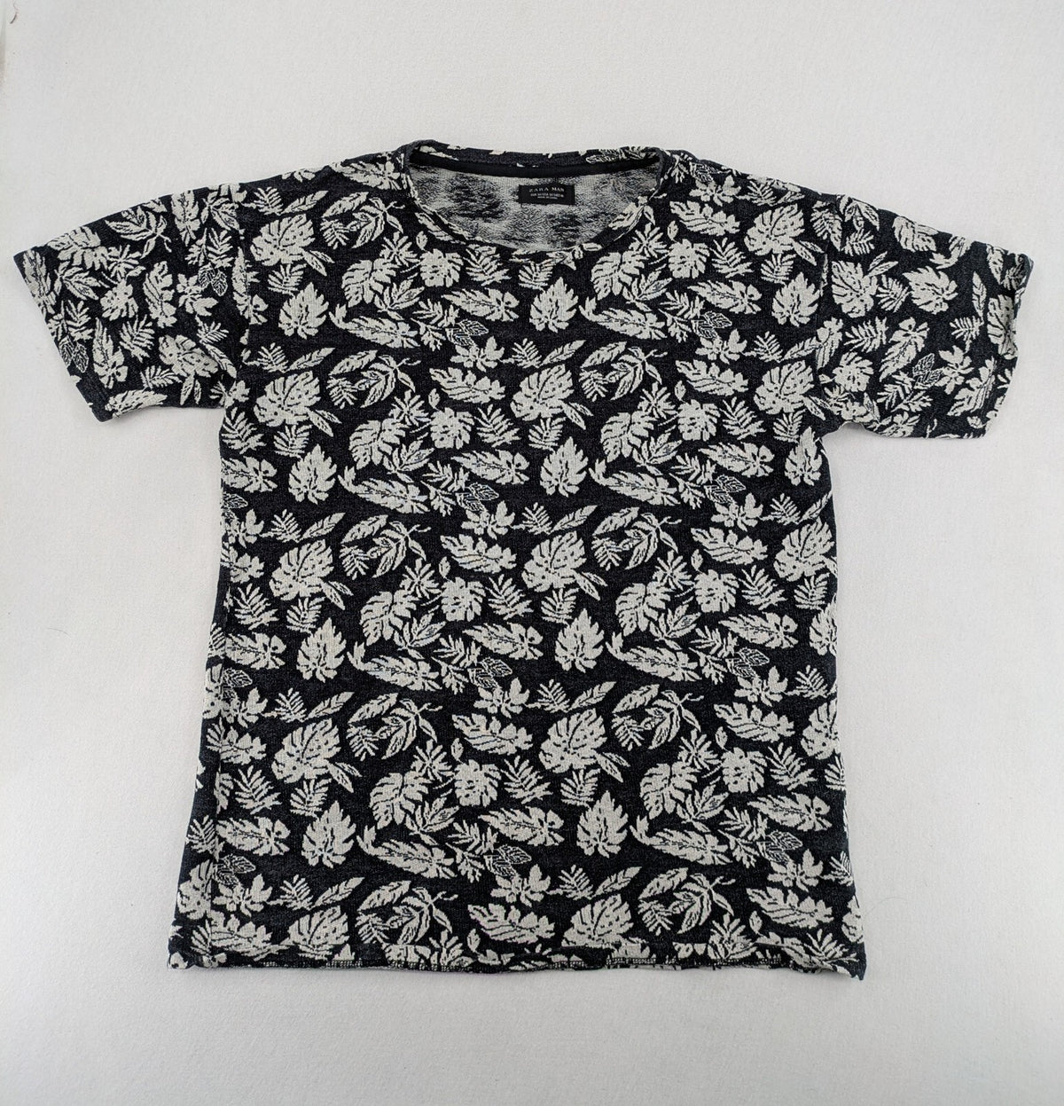 Zara Man black and white t-shirt with allover leaf print and textured knit fabric.