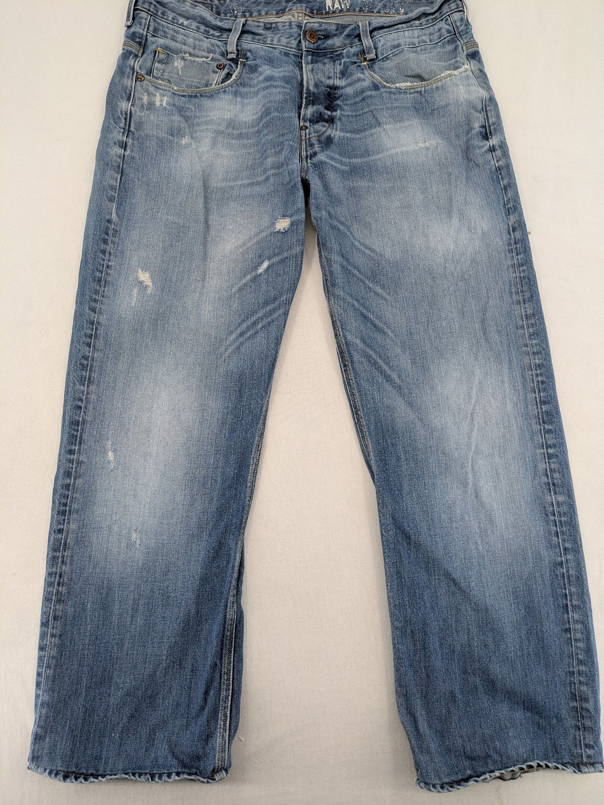 G-Star Raw blue straight jeans with distressed details and classic button fly.