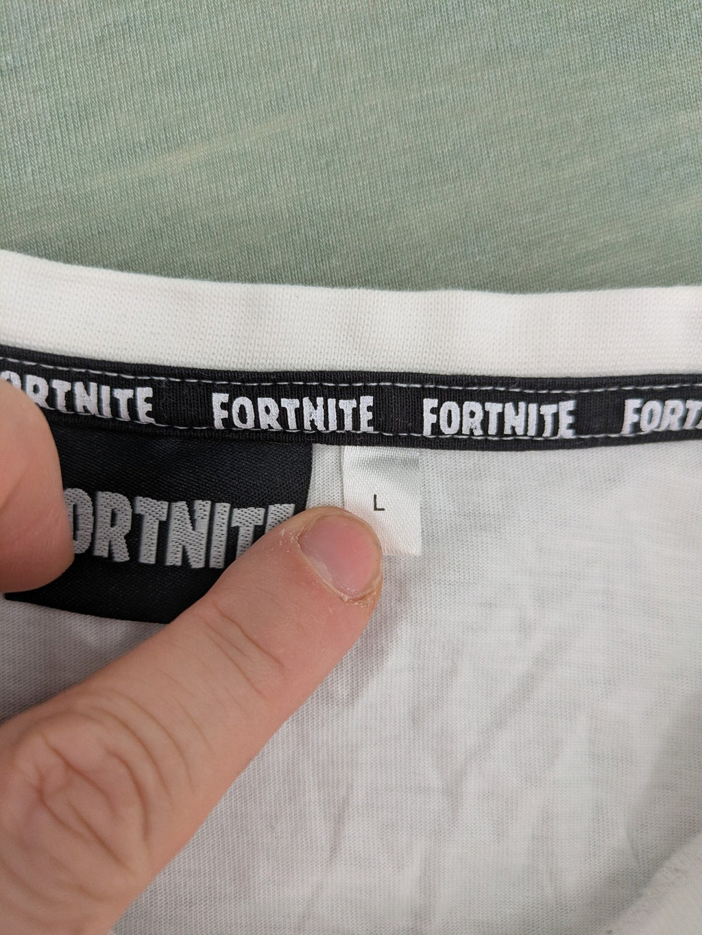 Fortnite white t-shirt with black chest stripe and Epic Games logo, 100% cotton.