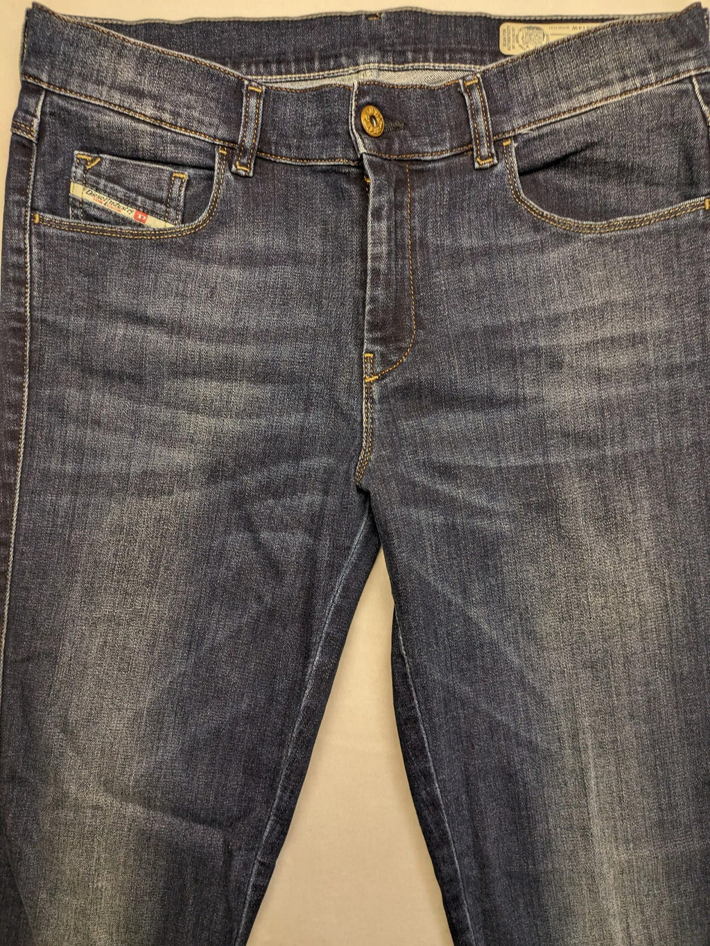 Diesel blue straight jeans with regular waist, dark wash, and stretch material.