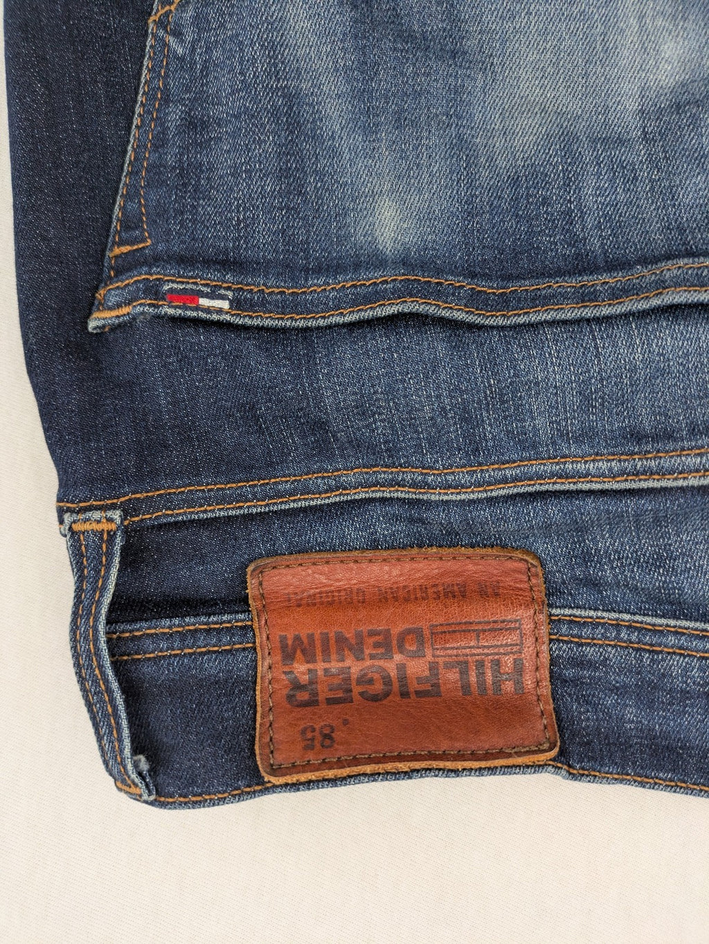 Tommy Hilfiger Denim blue straight jeans with five-pocket design and natural fading details.