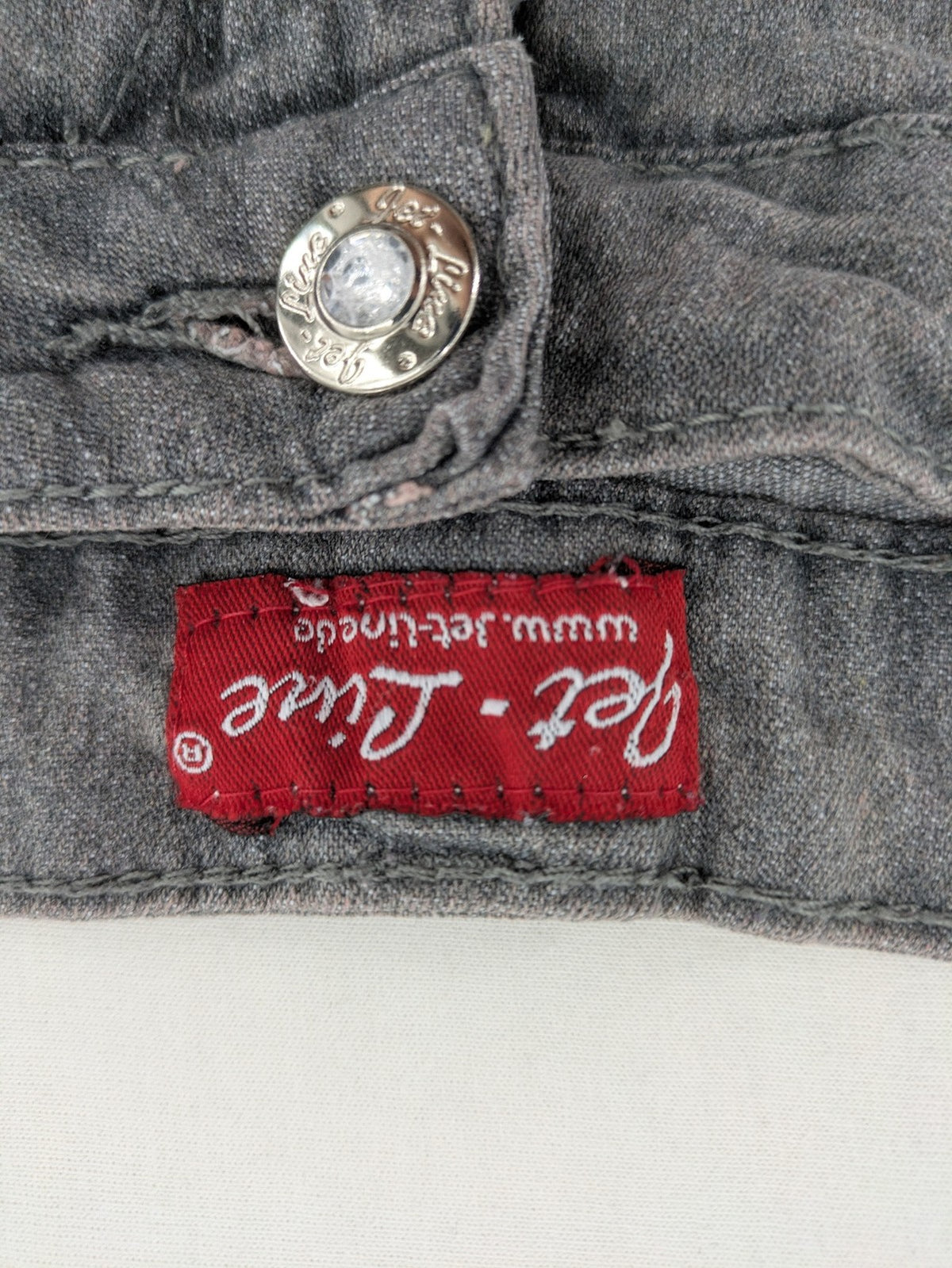 Jet Line grey straight jeans with embellished back pockets and frayed hem details.