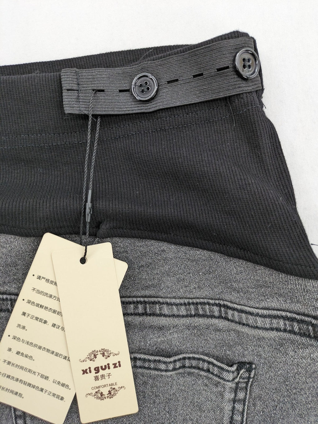 Damen grey maternity pants with black elastic belly band and stretch fabric.