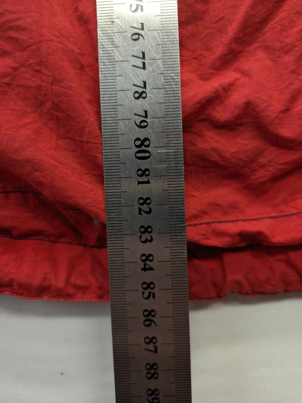 Bush Sportswear red trekking jacket with front zipper, multiple pockets, and striped lining.