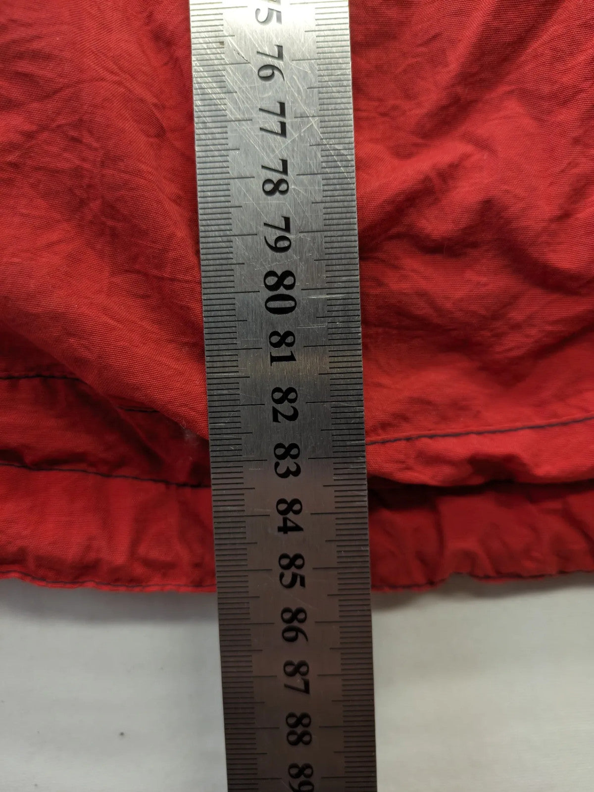 Bush Sportswear red trekking jacket with front zipper, multiple pockets, and striped lining.