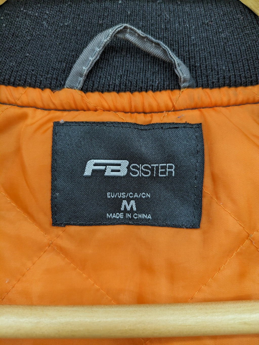 FB Sister orange bomber jacket with gray camouflage pattern and quilted lining.