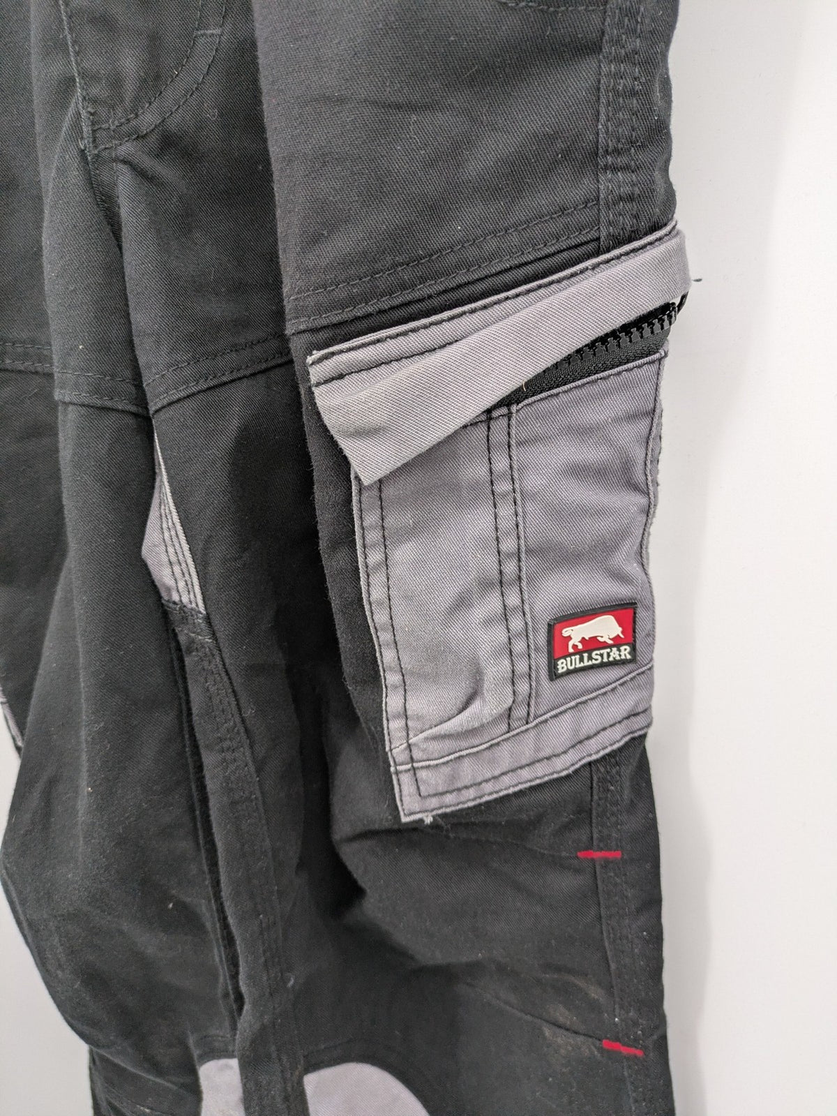 Cargo pants black grey two-tone design with red stitching and multiple pockets