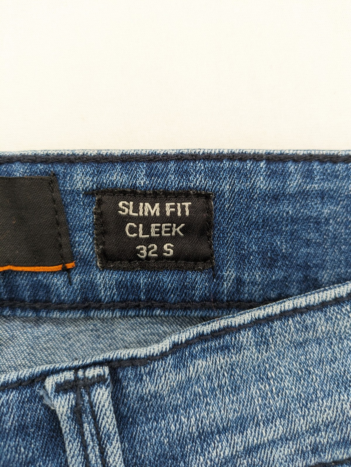 Crosshatch blue slim fit jeans with faded wash and logo patch on back pocket.