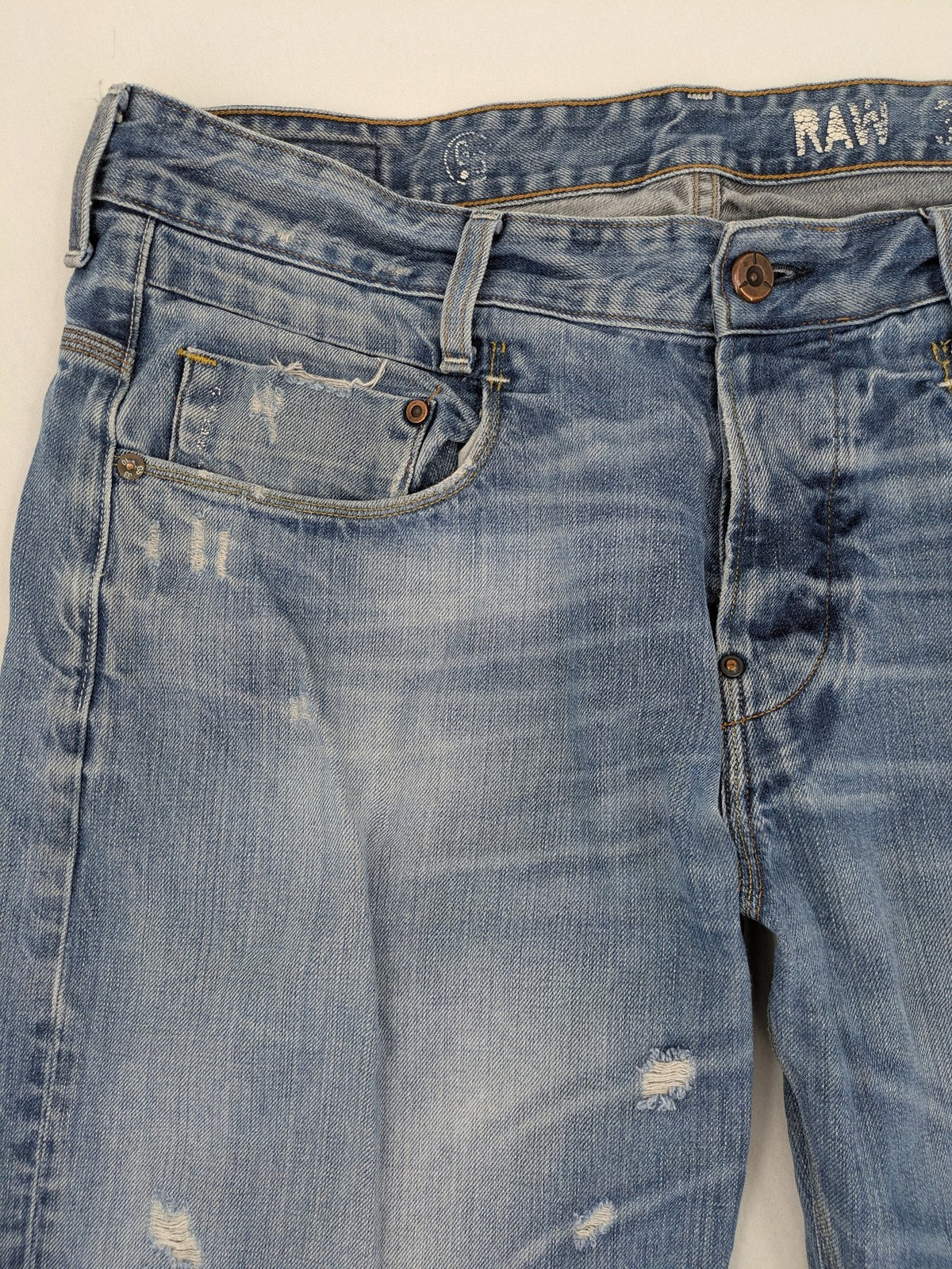 G-Star Raw blue straight jeans with distressed details and classic button fly.