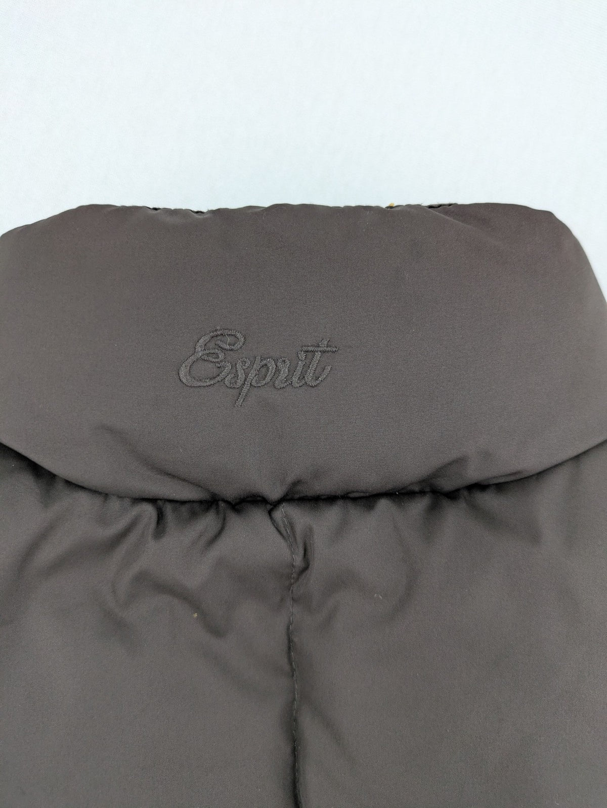Esprit brown puffer vest with high ribbed collar and zip button closure.
