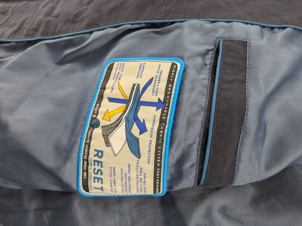 Reset navy parka jacket windproof with adjustable hood and zippered chest pocket.