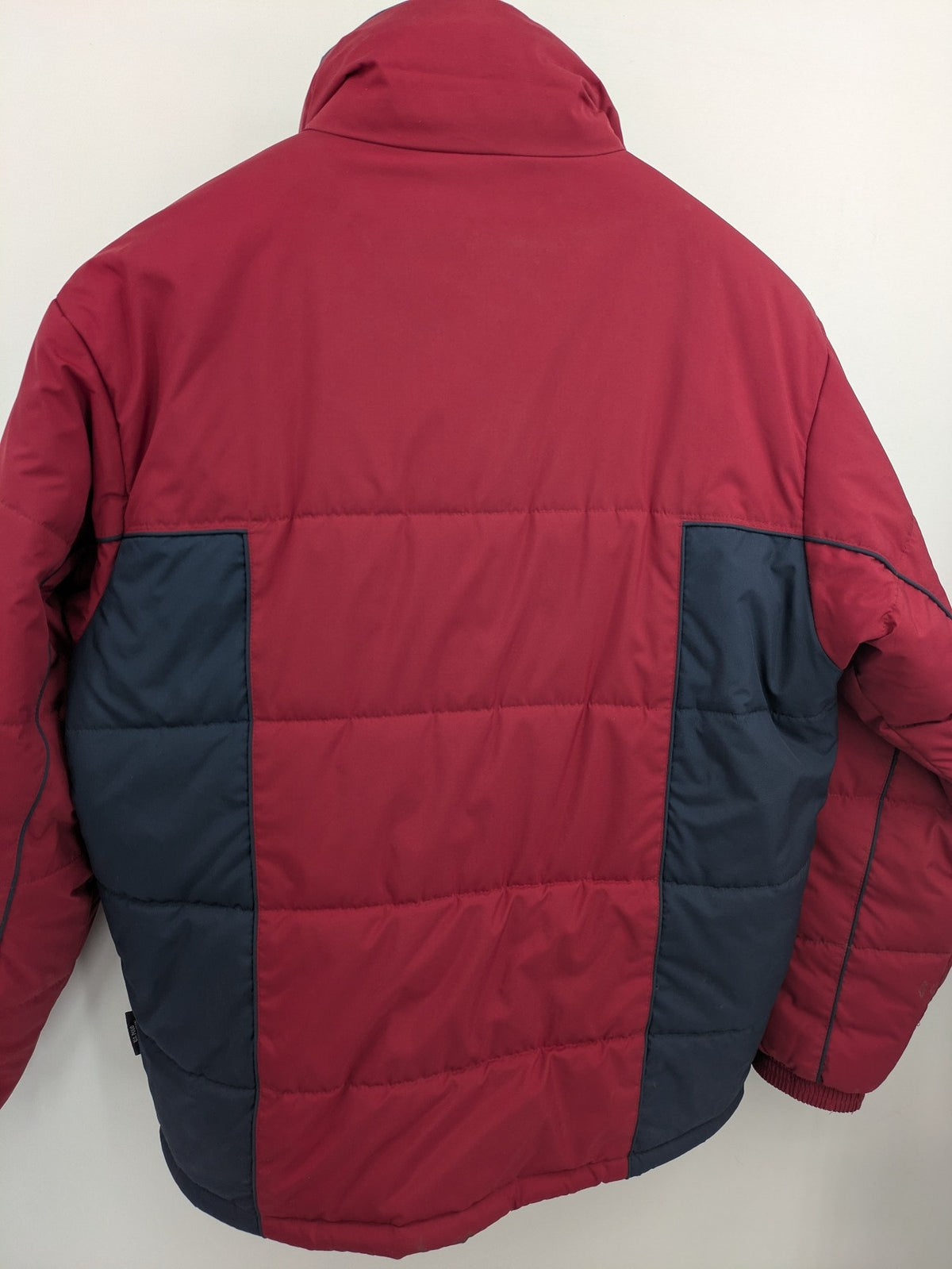 US Polo Assn. puffer jacket navy red two-tone design with embroidered logo and zip pockets.