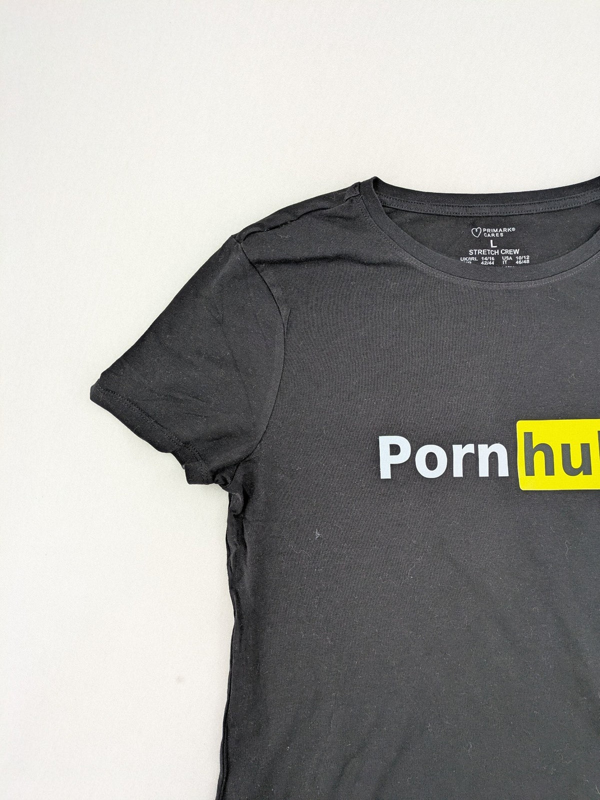 Primark black graphic t-shirt featuring yellow and white Pornhub logo on chest.