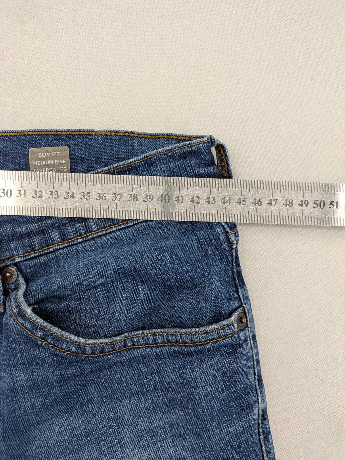Mustang blue tapered jeans with slim fit, medium rise, and classic denim texture.