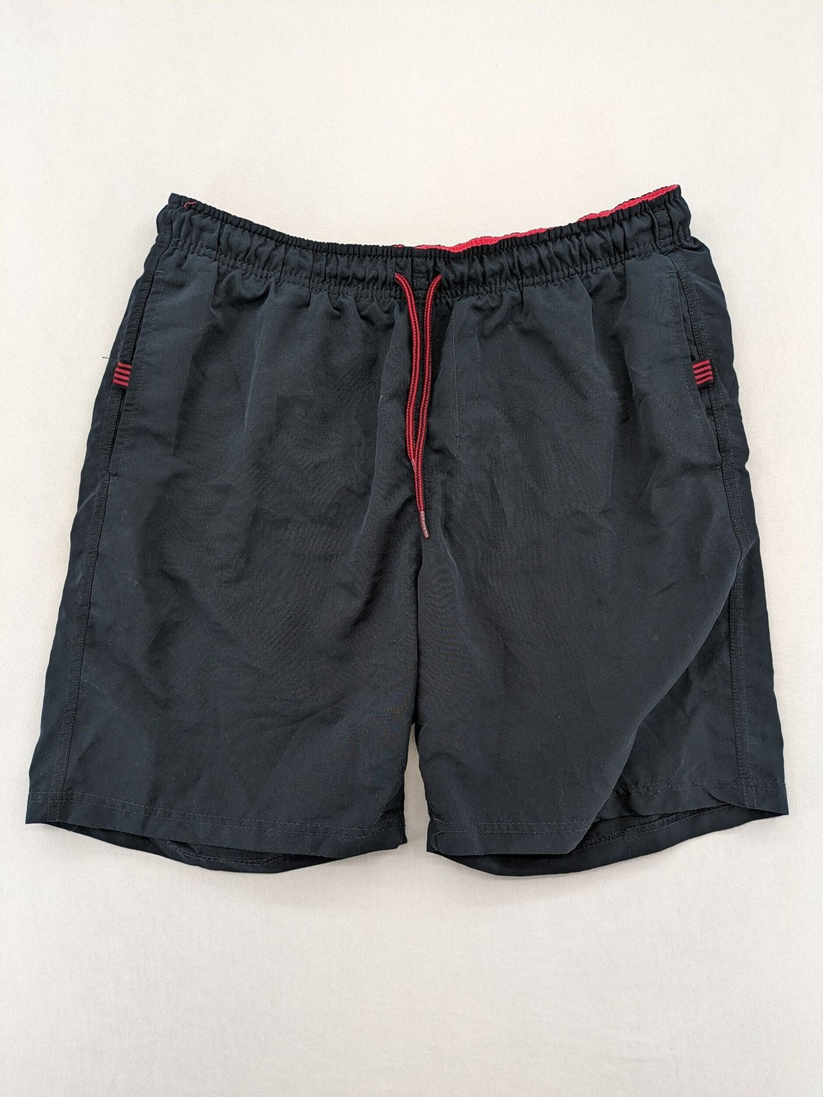 LC Waikiki navy swim shorts with red accents, elastic waistband, and quick-dry material.