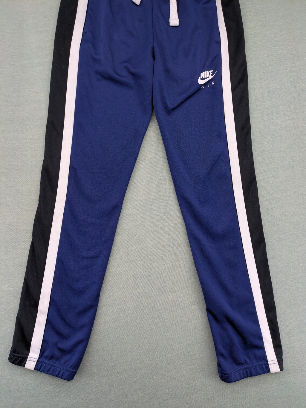 Nike Air blue jogging pants with black and white side stripes, elastic waistband.