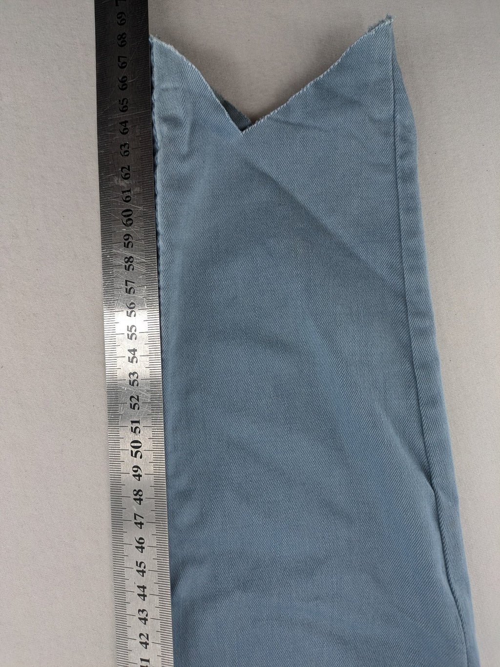 Yessica blue skinny jeans high rise with button fly and V-cut hem detail.