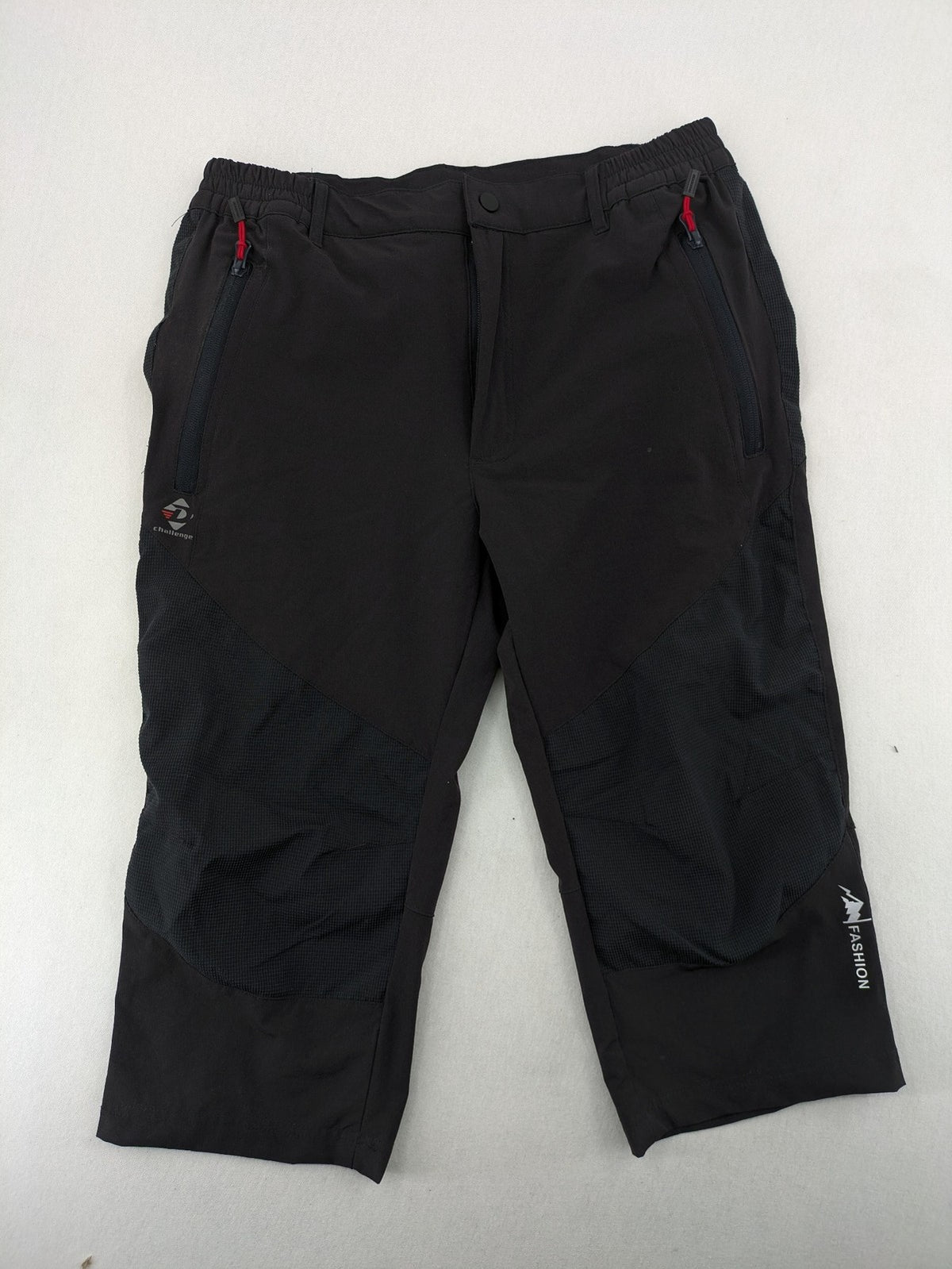 Outdoor black capri pants with elastic waistband and multiple zippered pockets.