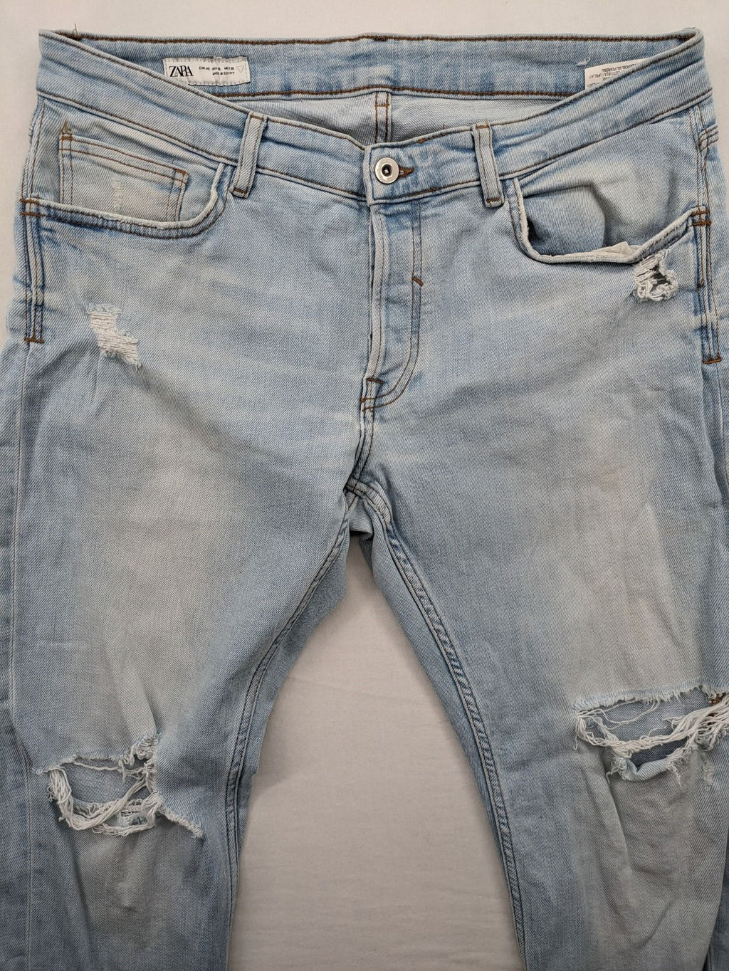 Zara blue straight jeans with distressed knees and classic button fly.