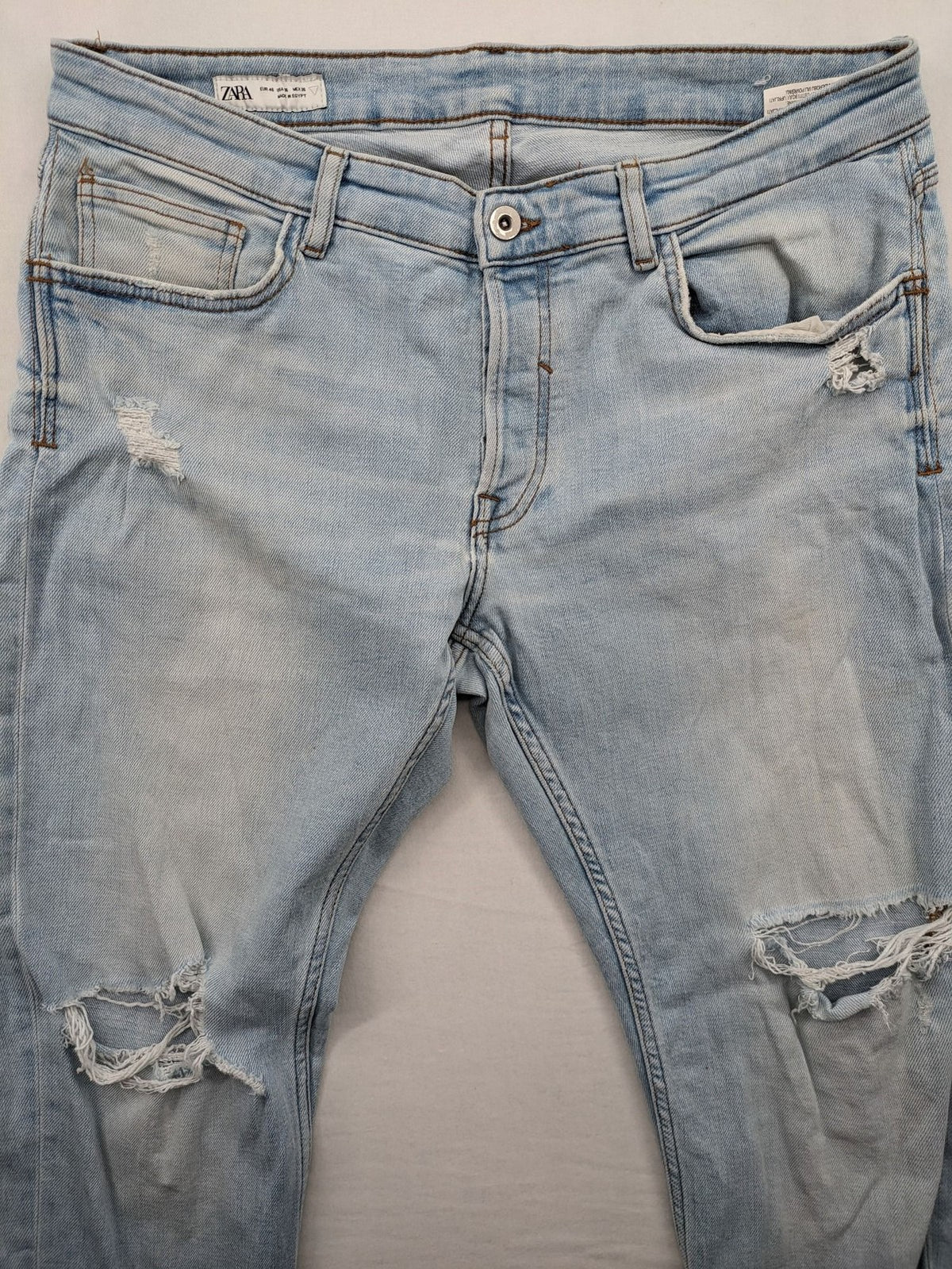 Zara blue straight jeans with distressed knees and classic button fly.