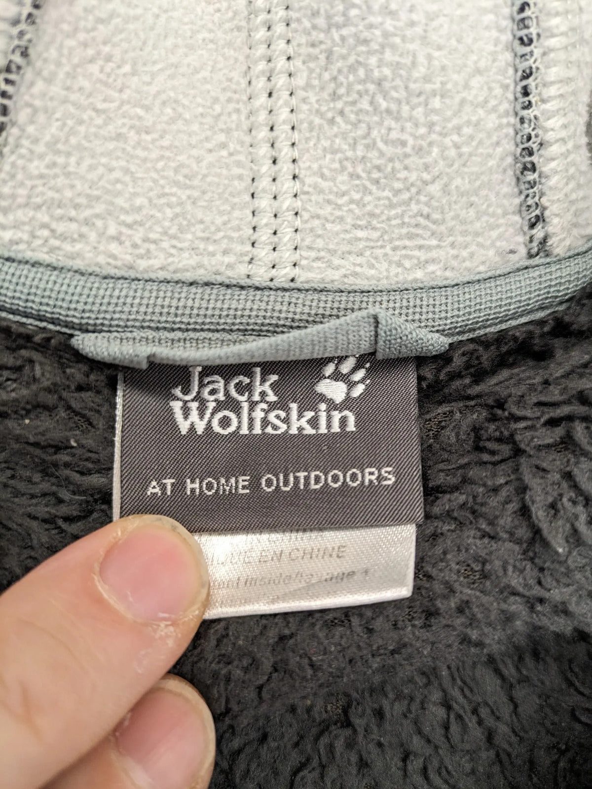 Jack Wolfskin grey fleece jacket with logo detailing and two front pockets.