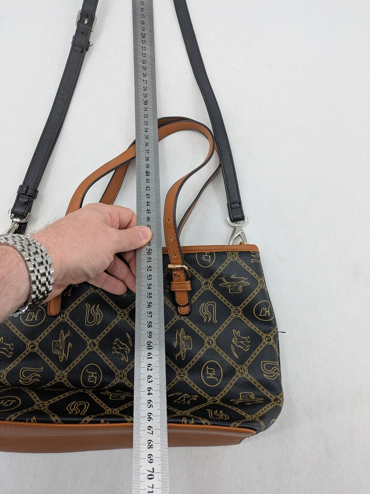 L&H brown and black handbag with monogram pattern and gold accents, versatile shoulder strap.