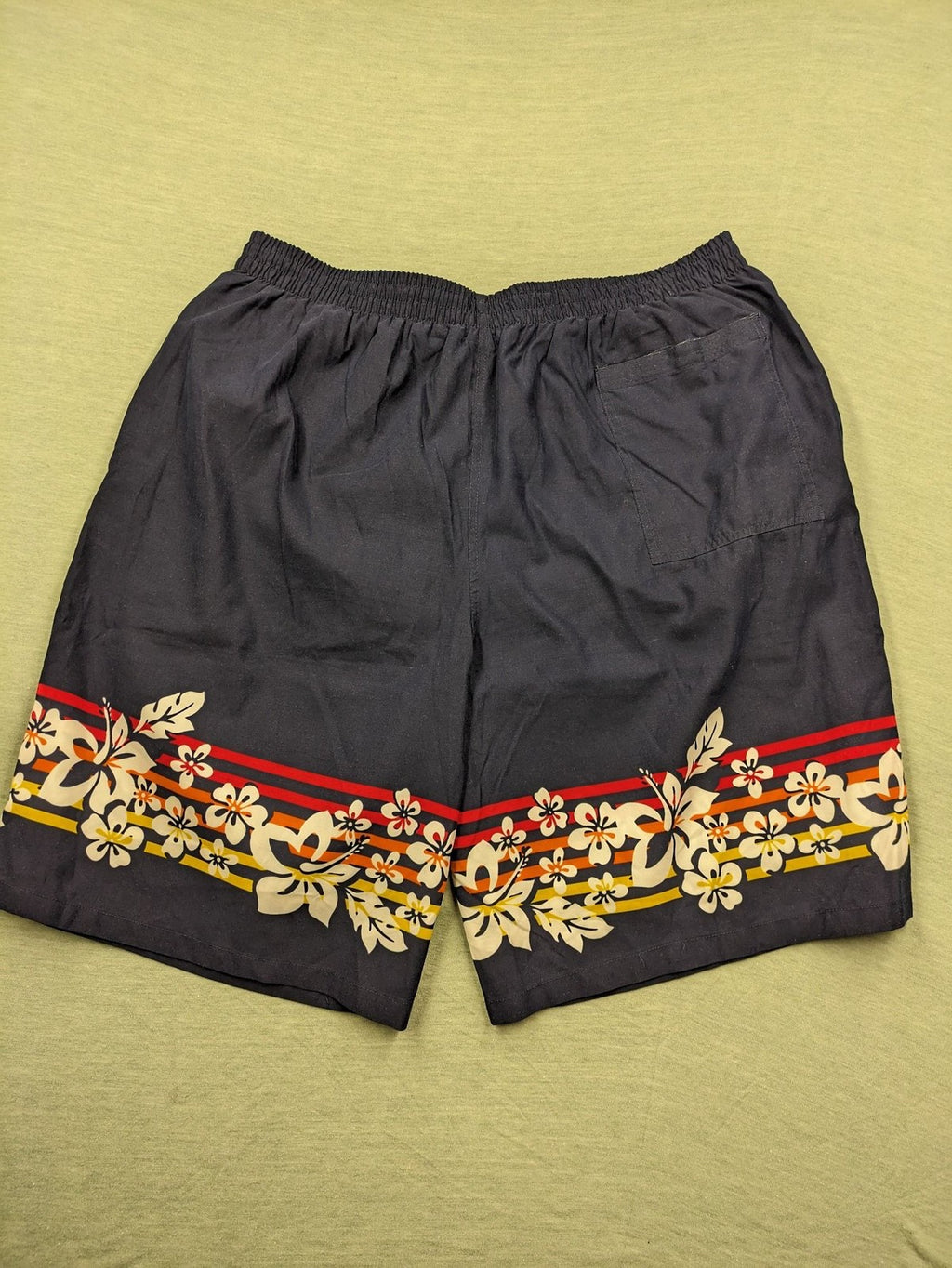 Muster multi swim shorts dark blue with vibrant Hawaii floral pattern and elastic waistband.