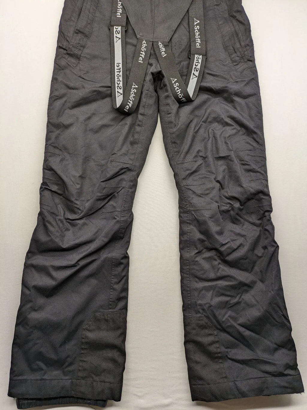 Schoffel black ski pants with adjustable straps, zip pockets, and snow gaiters.