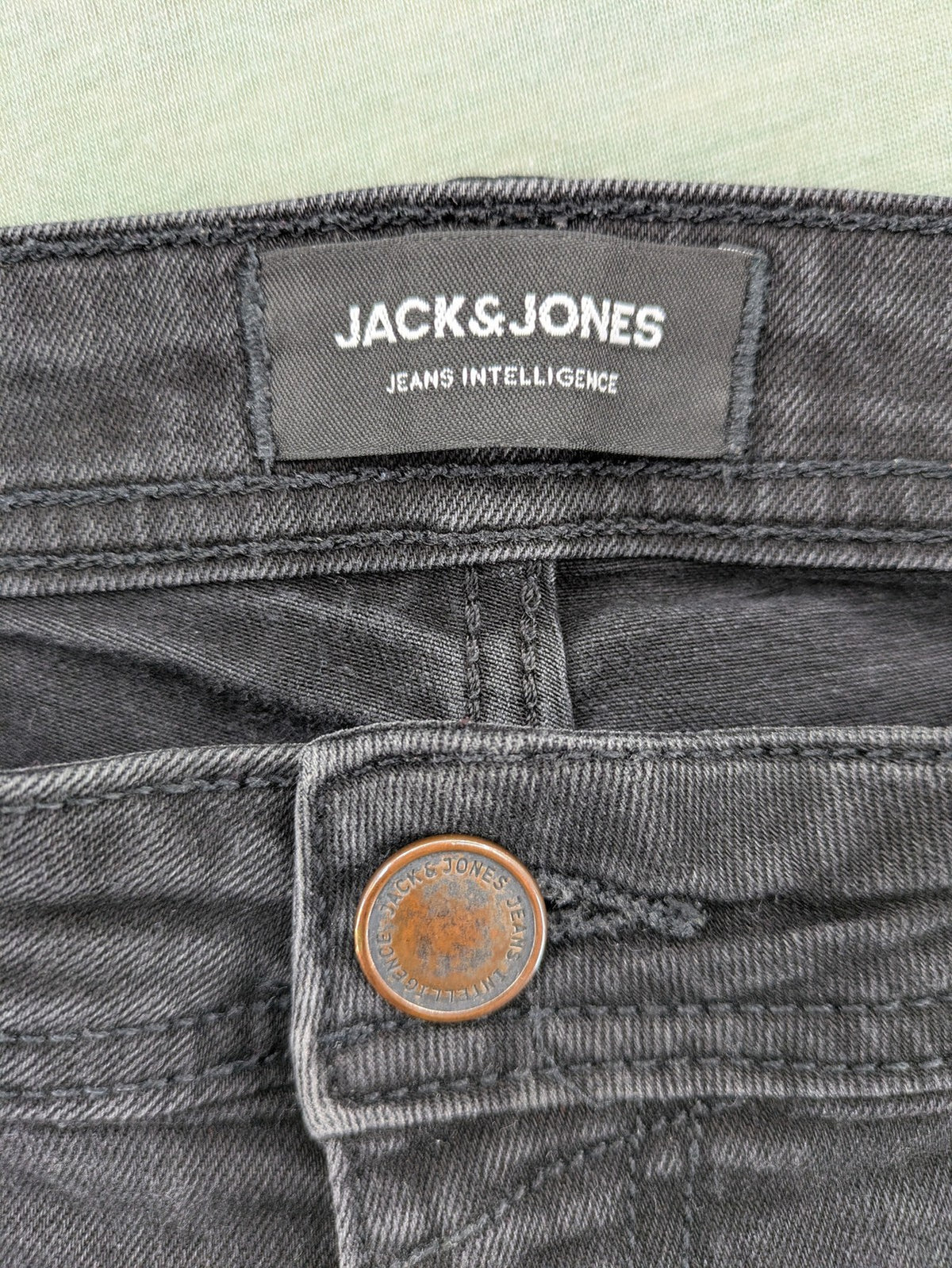 Jack & Jones black slim fit jeans faded wash stretch denim with logo detail.